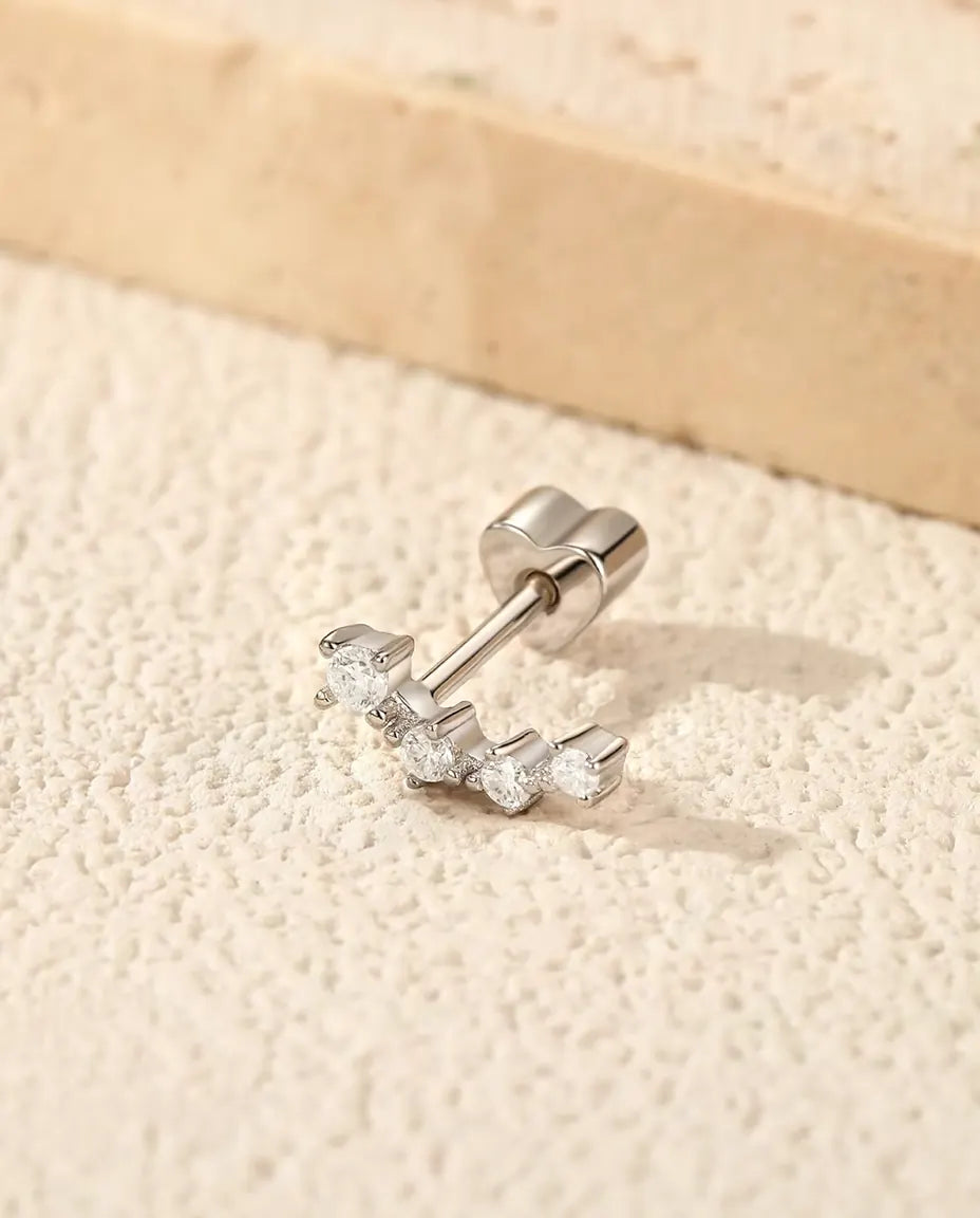 Moissanit Ear Climber Ohrstecker aus 925 Sterlingsilber - auf heller Strukturfläche neben einer Travertinplatte