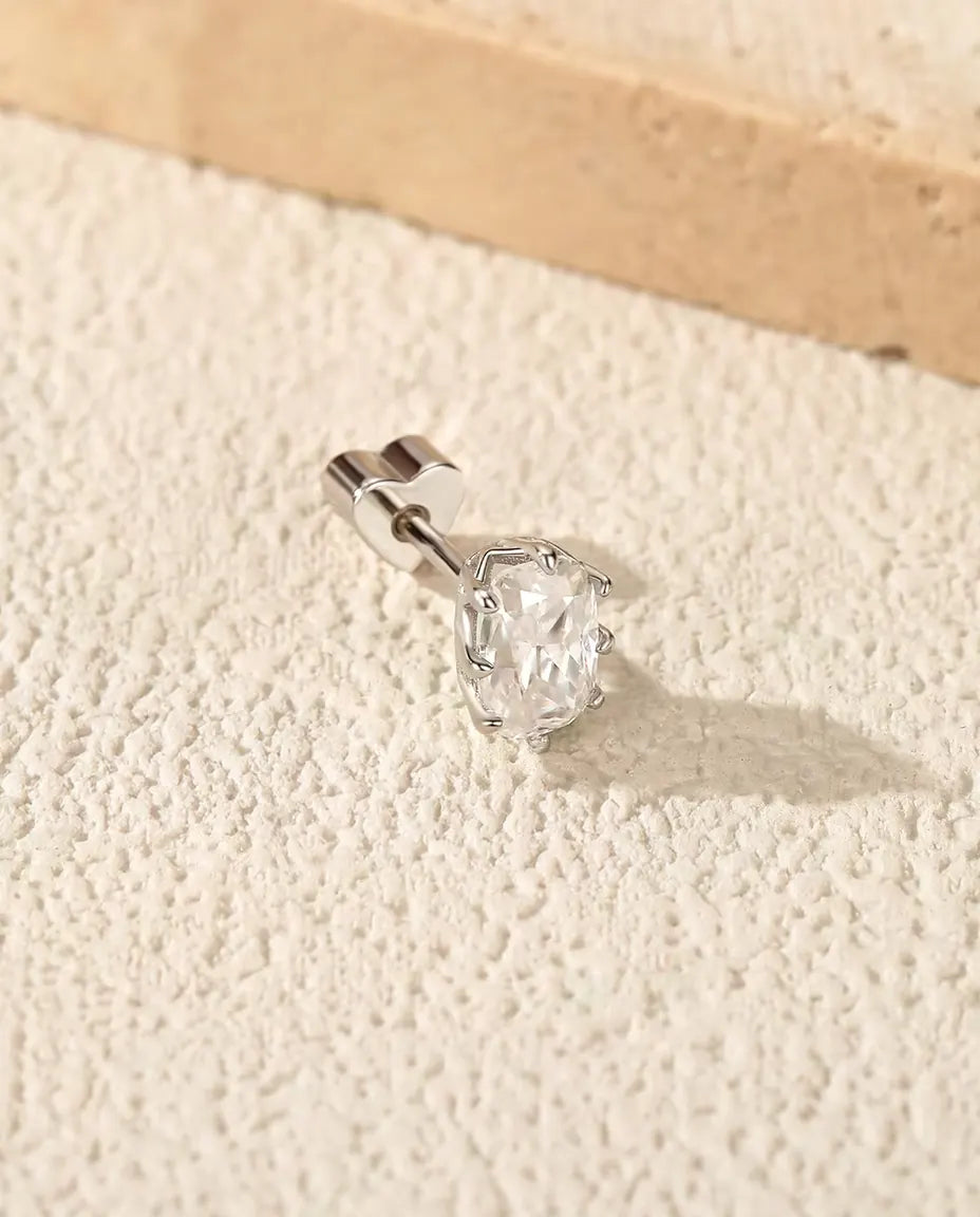 Moissanit Ohrstecker im Radiantschliff aus 925 Sterlingsilber - auf heller Strukturfläche neben einer Travertinplatte