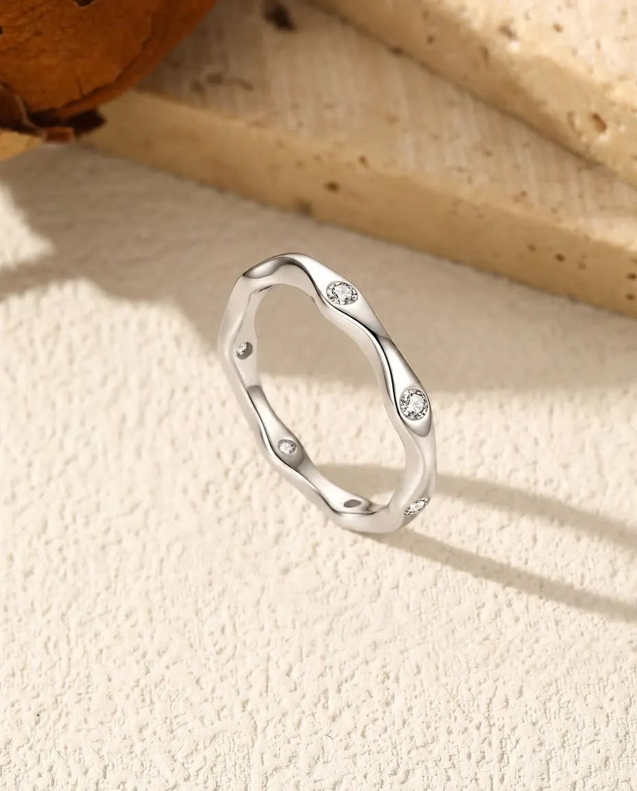 Moissanit Ring wellig aus 925 Sterlingsilber - aufrecht stehend auf heller Strukturfläche