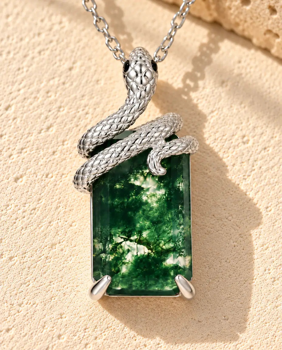 Moosachat Schlangen Kette aus 925 Sterlingsilber - auf heller Strukturfläche neben einem Travertinblock liegend