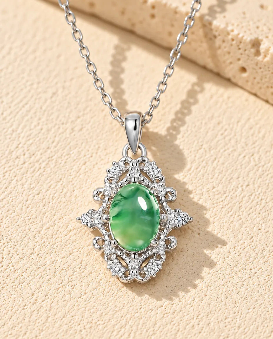 Ovale Moosachat Kette aus 925 Sterlingsilber - auf heller Strukturfläche neben einem Travertinblock liegend
