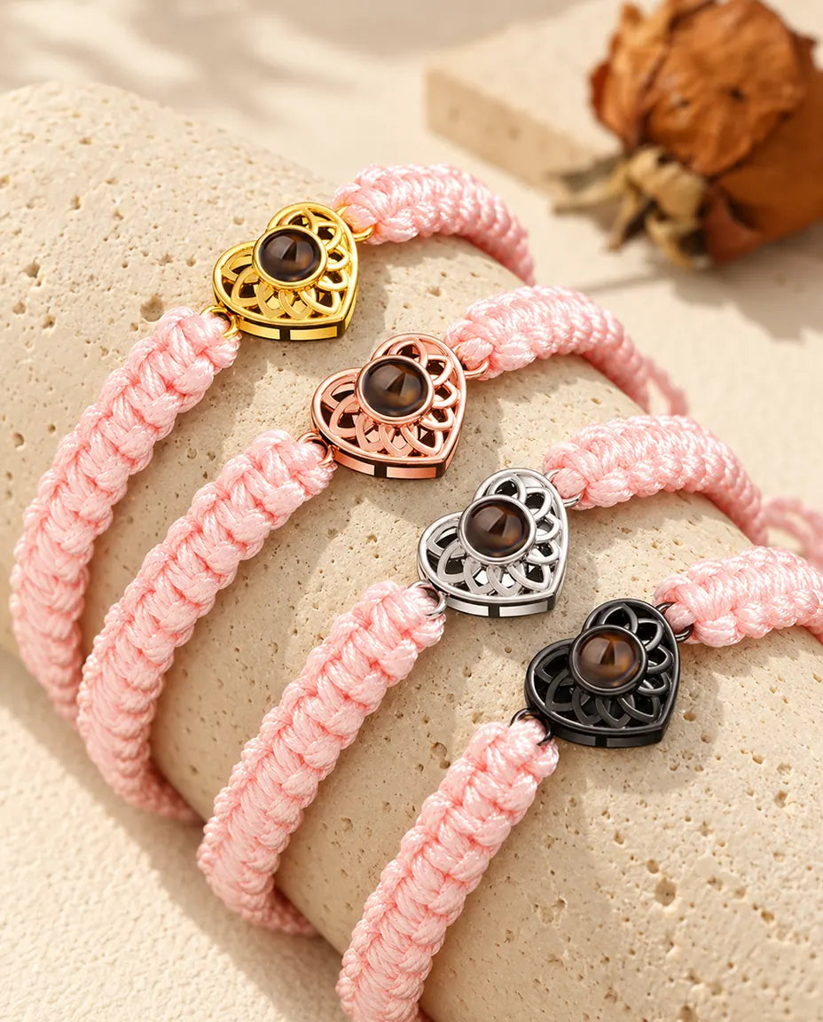 Armbänder mit rosa Flechtband und Herz in Gold, Roségold, Silber und Schwarz auf Travertin
