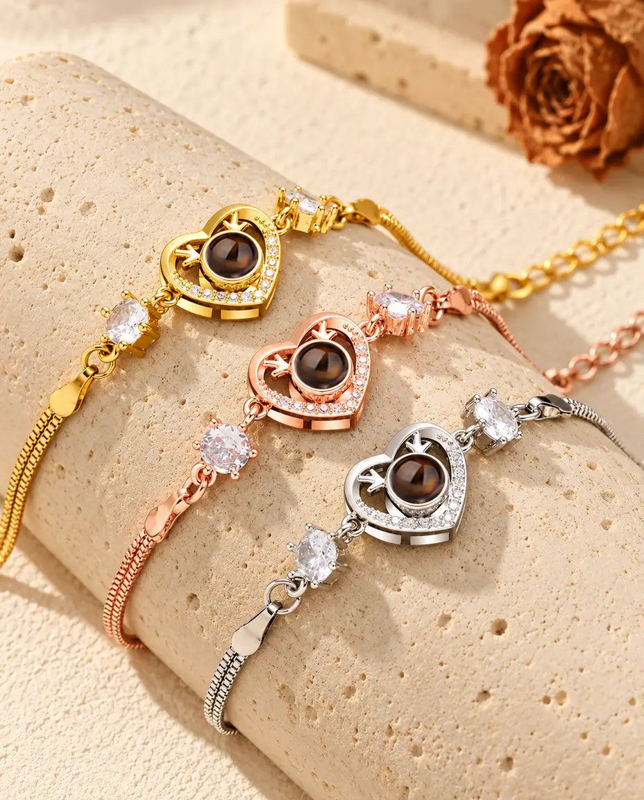 Drei Herz-Armbänder mit Geweih in Gold-, Roségold- und Silberfarben über einem Travertinblock