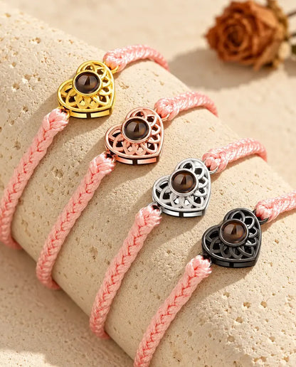 Armbänder mit schmalem rosa Flechtband und Herz in Gold, Roségold, Silber und Schwarz auf Travertin