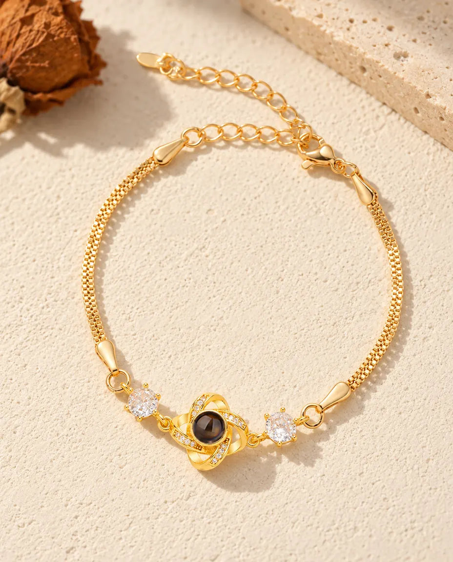 Draufsicht auf das goldfarbene Liebesknoten-Armband mit Bild im Stein