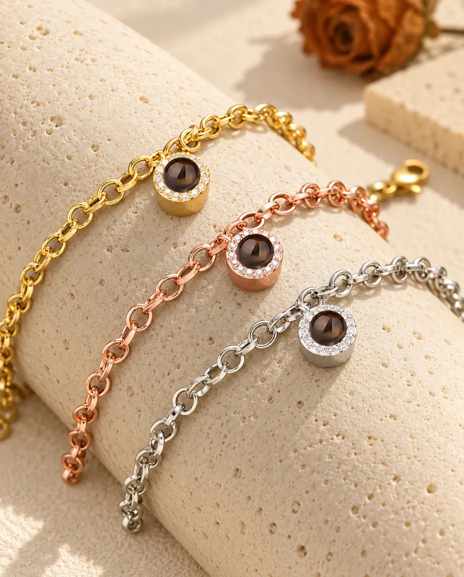 Zirkonia-Armbänder in Gold, Roségold und Silber über einem Travertinblock