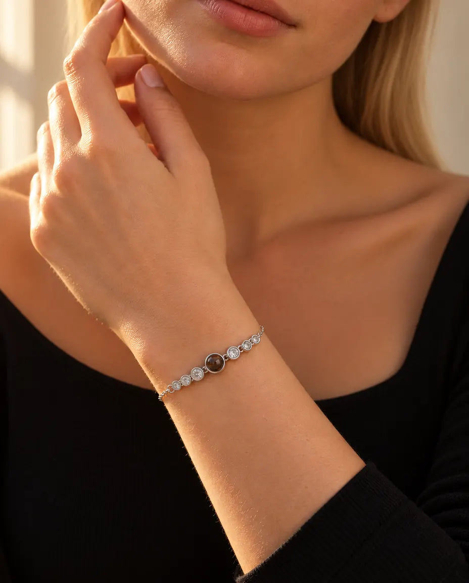 Frau berührt ihre Kinnlinie und trägt das silberfarbene Armband mit Zirkonia-Reihe und Bild im Stein