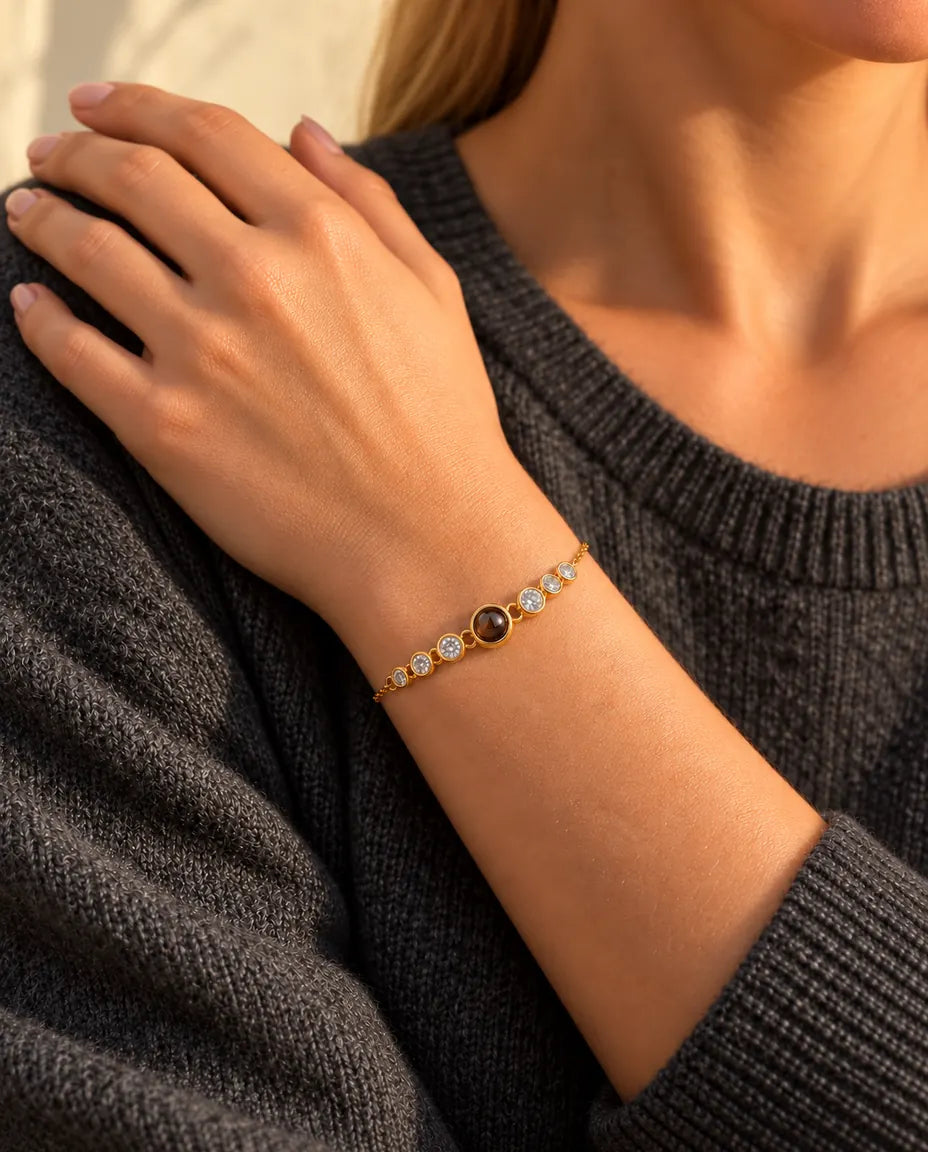 Nahaufnahme des goldfarbenen Zirkonia-Armbands am Handgelenk, die Hand ruht auf ihrer Schulter