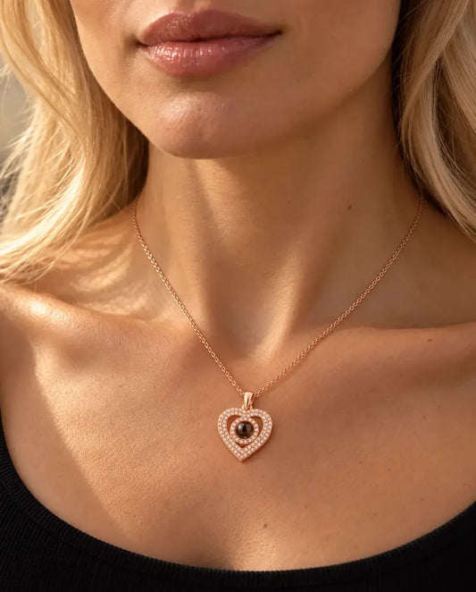 Frau in schwarzem Strickoberteil trägt die roségoldfarbene Doppelherz-Kette mit Bild im Stein