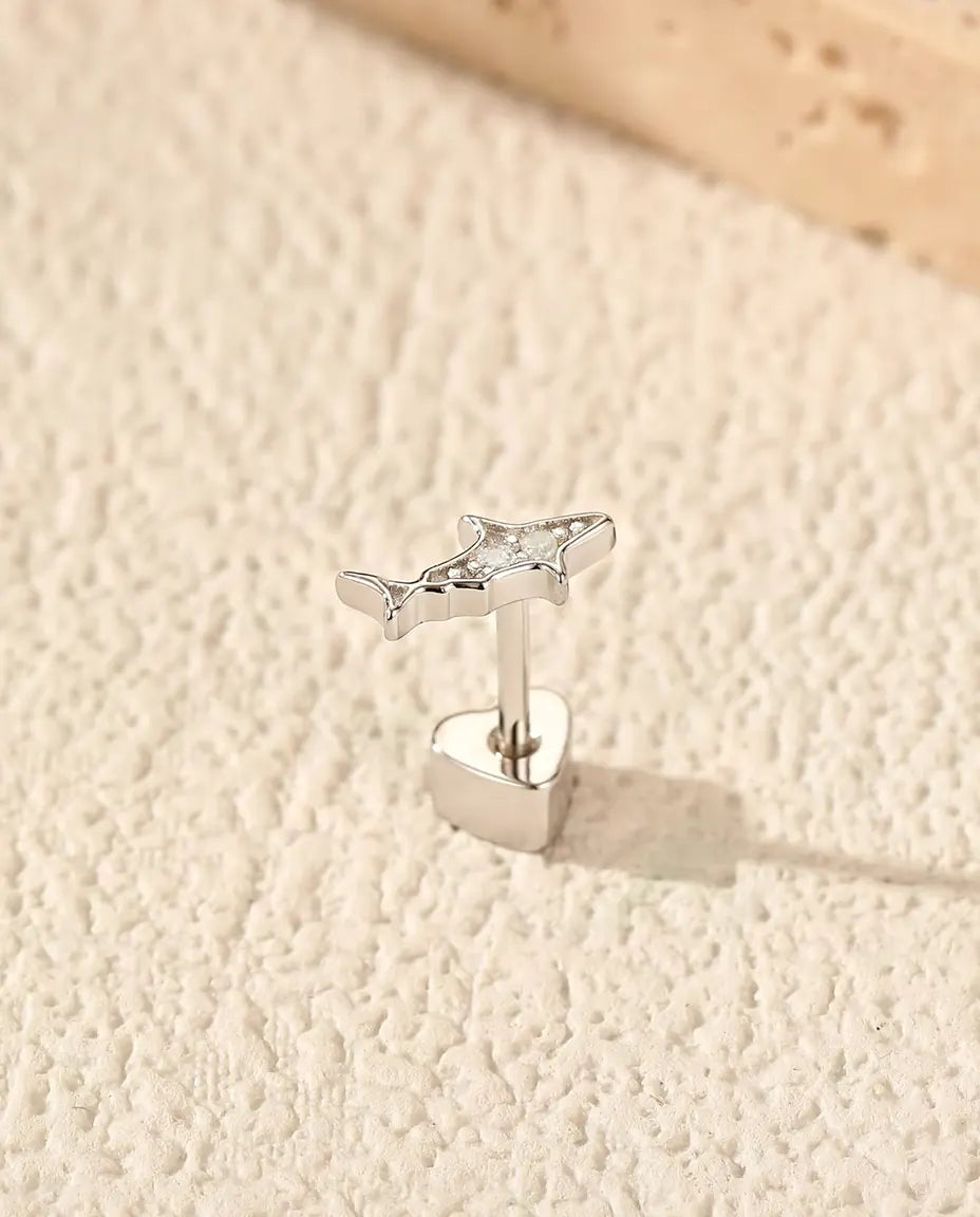 Hai Ohrstecker aus 925 Sterlingsilber mit Moissanit - aufrecht auf dem herzförmigen Verschluss stehend, auf heller Strukturfläche