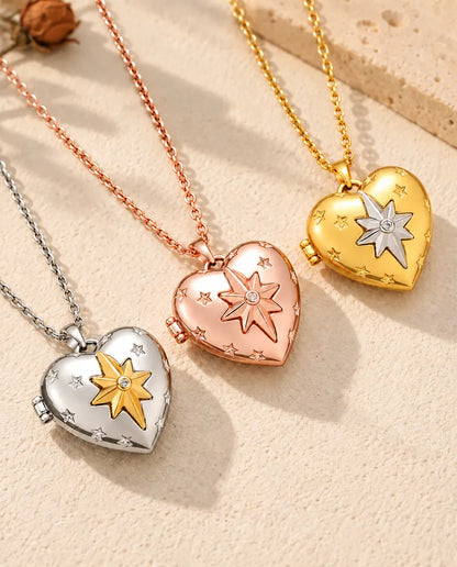 Herz-Foto-Medaillon mit Nordstern in Silber-, Roségold- und Goldfarbe schräg auf cremefarbenem Putz