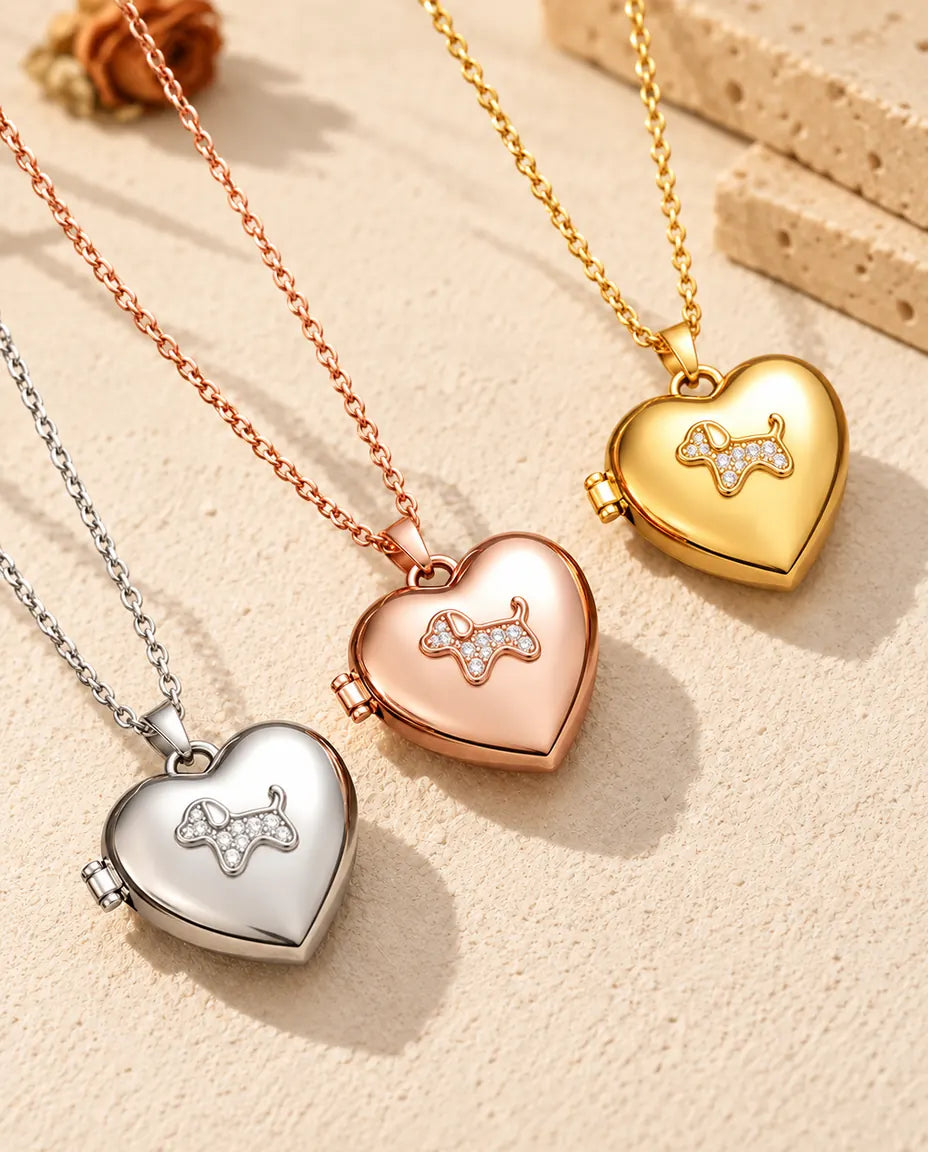Herz-Foto-Medaillon mit Welpe in Silber-, Roségold- und Goldfarbe schräg auf cremefarbenem Putz