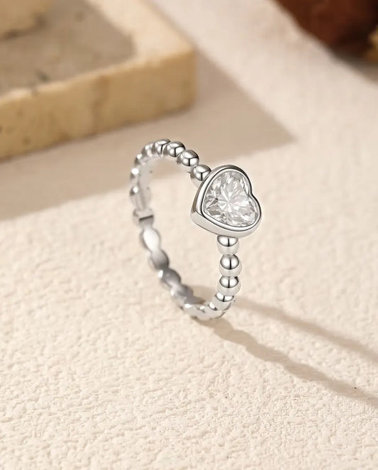 Herz Moissanit Ring aus 925 Sterlingsilber - aufrecht stehend auf heller Strukturfläche