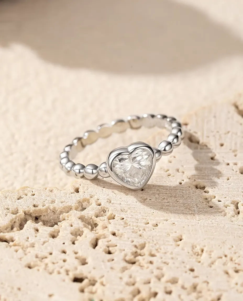 Herz Moissanit Ring aus 925 Sterlingsilber - auf poröser Travertinfläche