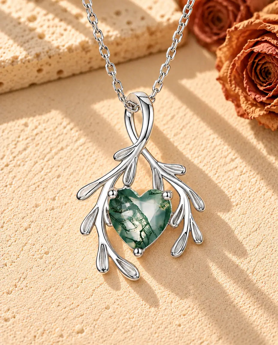 Herz Moosachat Kette mit Zweigen aus 925 Sterlingsilber - auf heller Strukturfläche neben einem Travertinblock liegend