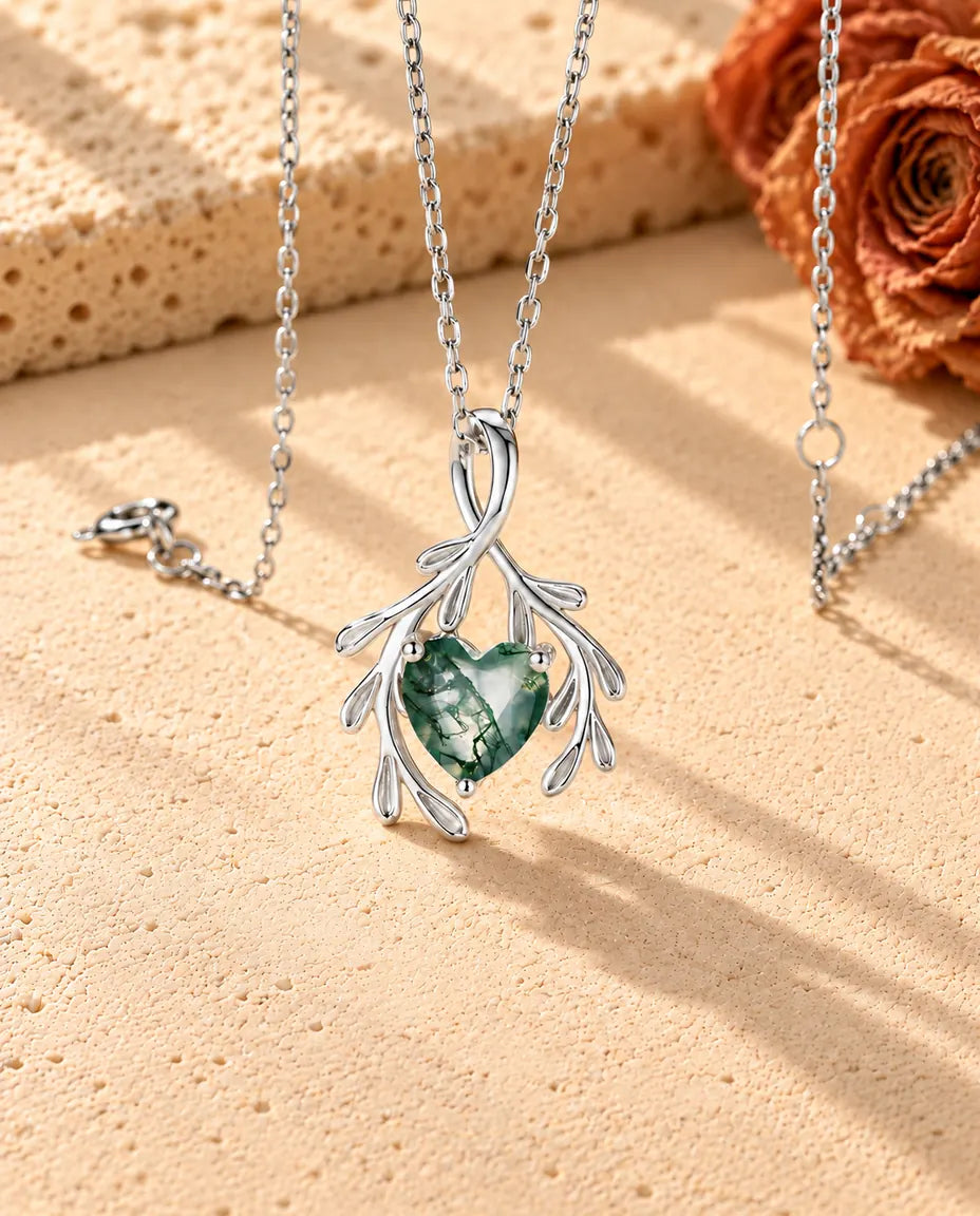 Herz Moosachat Kette mit Zweigen aus 925 Sterlingsilber - schräg aufgenommen auf heller Strukturfläche