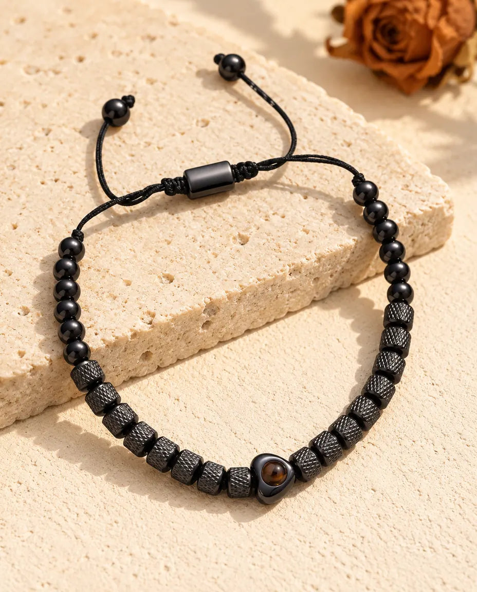 Schwarzes Armband mit strukturierten Perlen, Herzperle, Schieber und Kordelenden