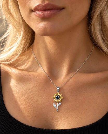 Frau im schwarzen Oberteil trägt die silberne Sonnenblumen-Kette mit Stiel