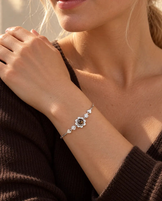 Frau legt die Hand auf ihre Schulter und trägt das silberfarbene Kleeblatt-Armband