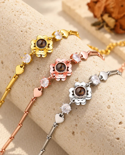 Drei Kleeblatt-Armbänder in goldfarben, roségoldfarben und silberfarben über einem Travertinblock