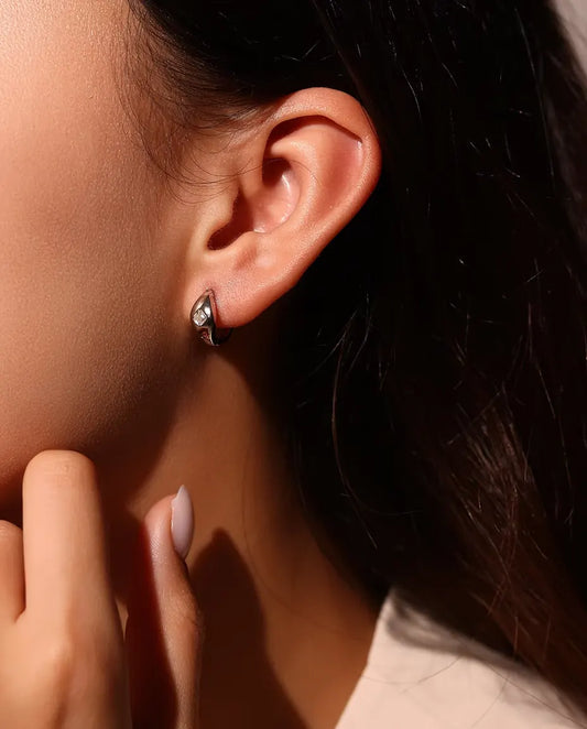 Moissanit Creolen im Asscher-Schliff aus 925 Sterlingsilber - am Ohr des Models getragen, Hand nah am Gesicht
