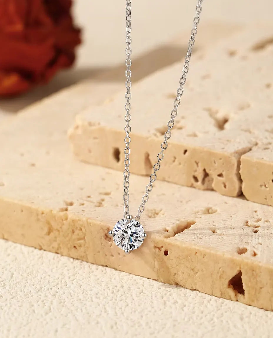 Moissanit Kette 1 ct aus 925 Sterlingsilber - Anhänger über der Kante einer Travertinplatte hängend