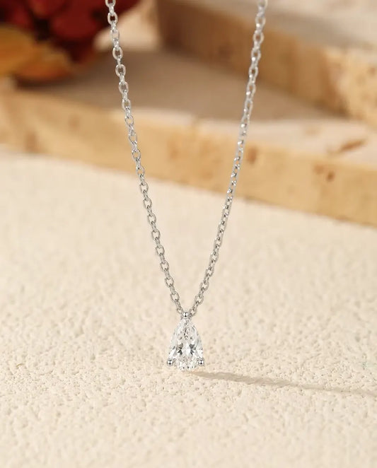 Moissanit Kette 1 ct aus 925 Sterlingsilber - Anhänger auf heller Fläche neben einer Travertinplatte