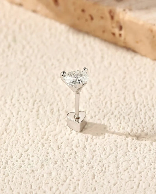 Runde Moissanit Ohrstecker mit drei Krappen aus 925 Sterlingsilber - aufrecht auf dem herzförmigen Verschluss stehend, auf heller Strukturfläche