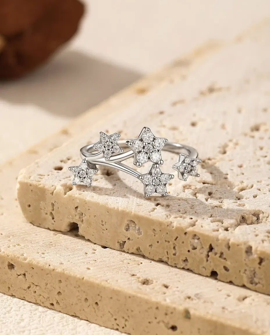 Moissanit Ring mit Sternen aus 925 Sterlingsilber - auf der Kante einer Travertinplatte