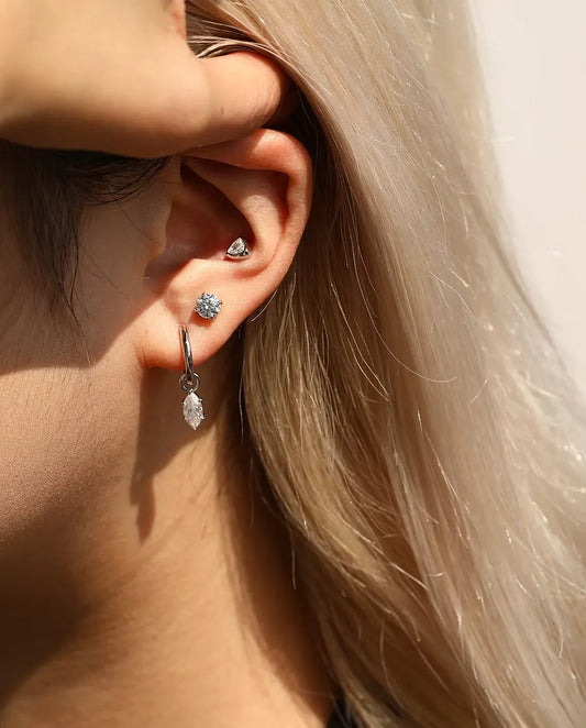 Runde Moissanit Solitär-Ohrstecker mit vier Krappen aus 925 Sterlingsilber - am Model getragen, Haare hinters Ohr gestrichen