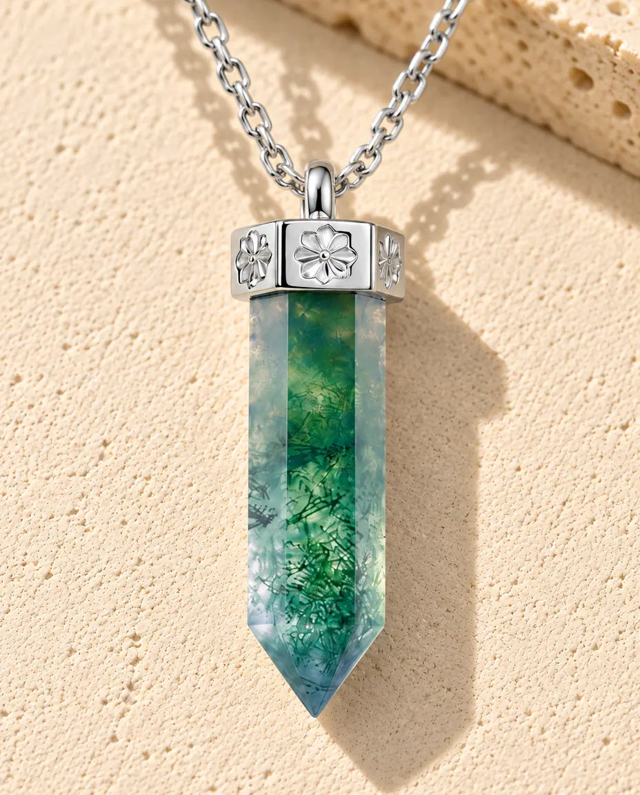 Moosachat Kette mit Spitze aus 925 Sterlingsilber - auf heller Strukturfläche neben einem Travertinblock liegend