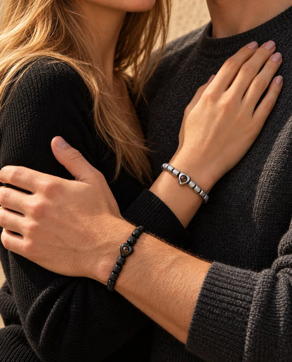 Paar in einer Umarmung, sie trägt das silberfarbene Armband mit Herzperle, er das schwarze