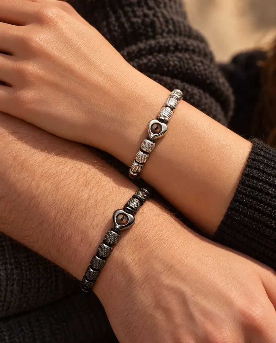 Nahaufnahme ihrer und seiner Handgelenke mit passenden Herzperlen-Armbändern in silberfarben und schwarz