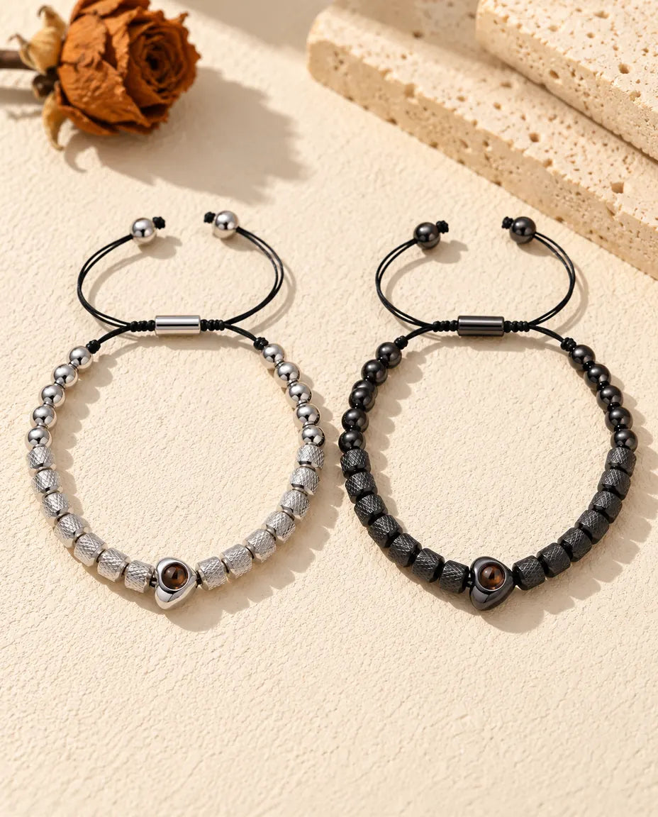 Draufsicht auf die silberfarbenen und schwarzen Partnerarmbänder mit Schiebern und Kordelenden