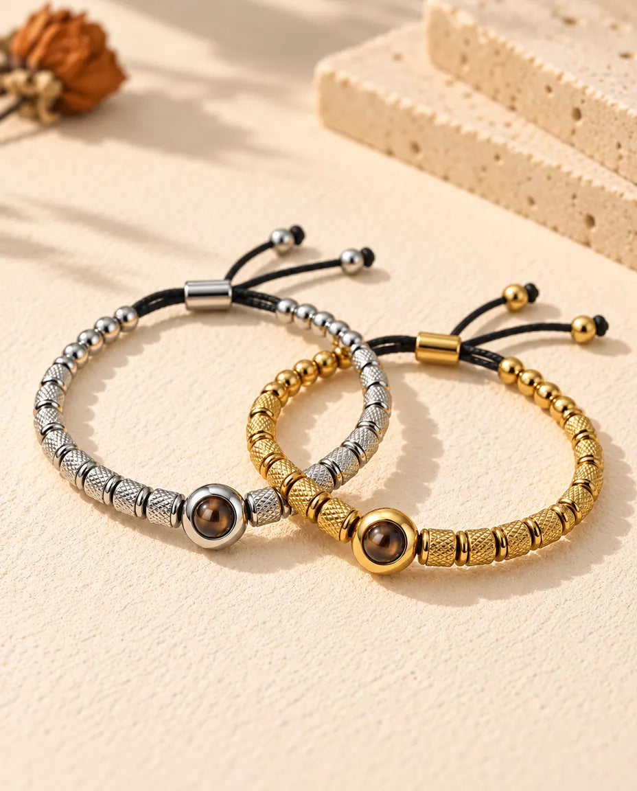Silberfarbenes und goldfarbenes Perlenarmband ineinander verschlungen wie zwei Ringe