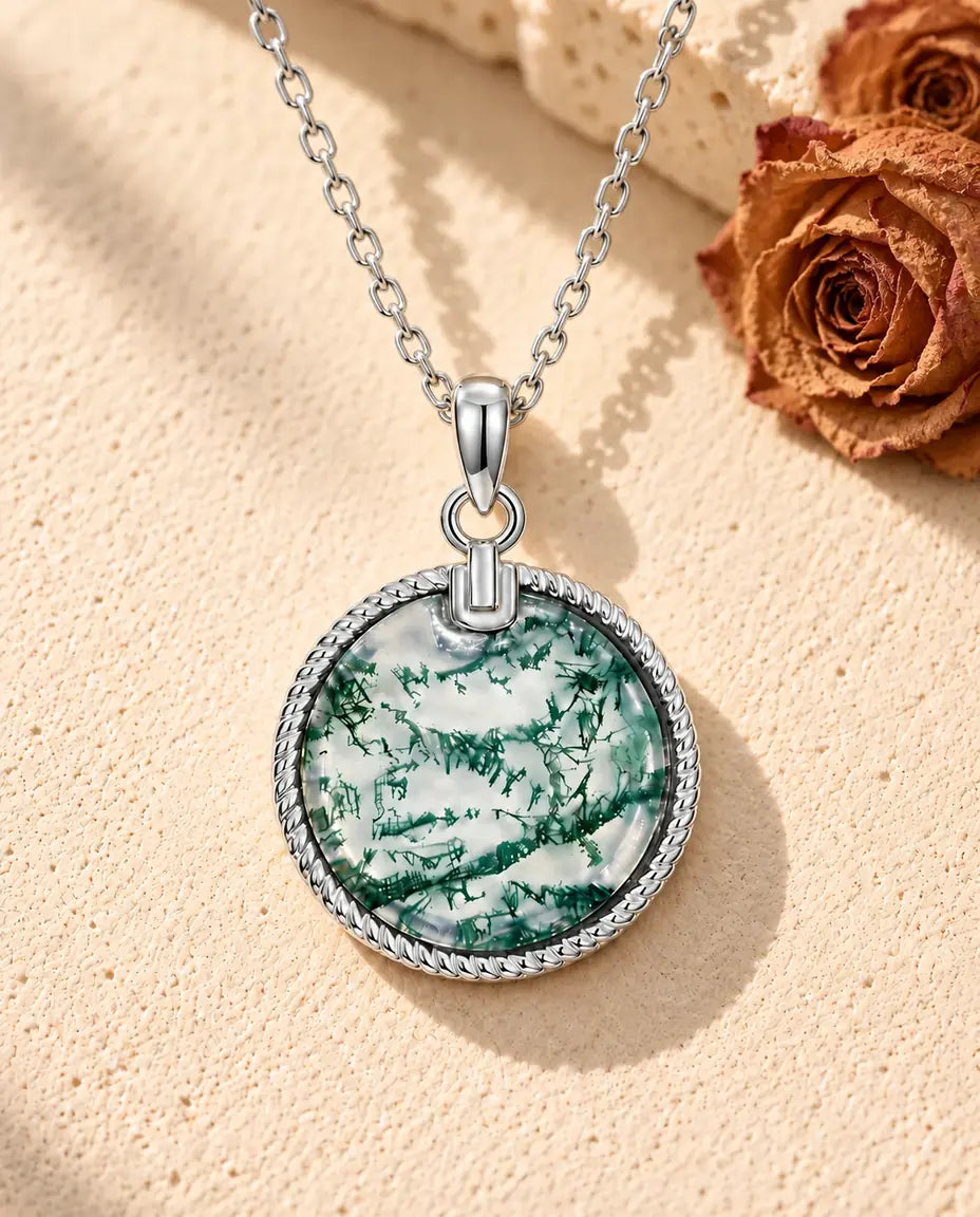 Runde Moosachat Medaillon Kette aus 925 Sterlingsilber - auf heller Strukturfläche neben einem Travertinblock liegend
