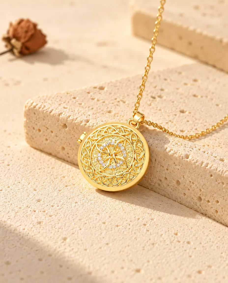 Goldfarbenes rundes Foto-Medaillon mit keltischem Knoten als Kette an einem Travertinblock