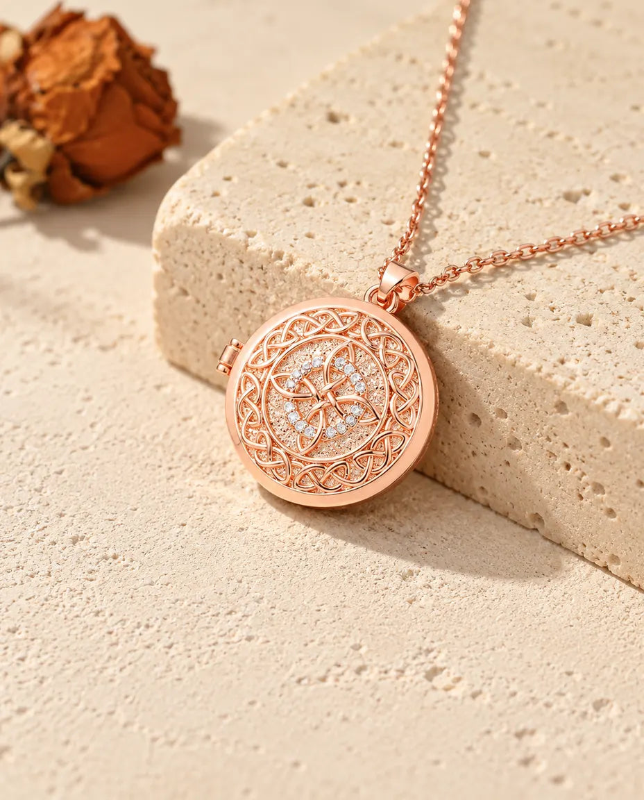 Roségoldfarbenes rundes Foto-Medaillon mit keltischem Knoten auf Travertin im warmen Sonnenlicht
