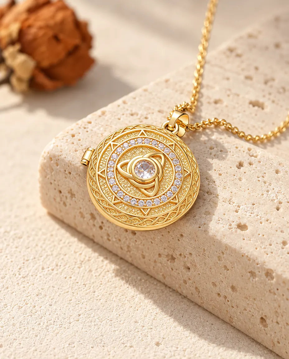 Goldfarbene runde Triquetra-Medaillon-Kette mit Mittelstein über der Kante eines Travertinblocks