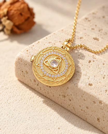 Goldfarbene runde Triquetra-Medaillon-Kette mit Mittelstein über der Kante eines Travertinblocks