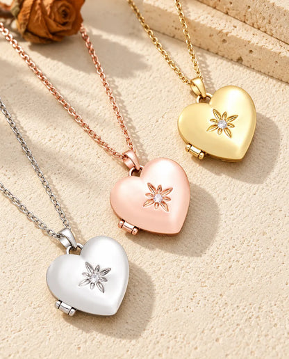 Satiniertes Herz-Foto-Medaillon in Silber-, Roségold- und Goldfarbe schräg auf cremefarbenem Putz