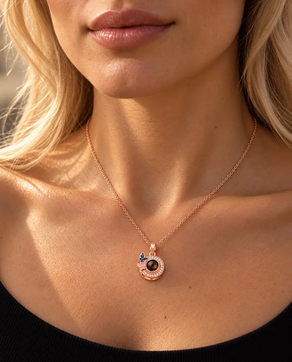 Frau in schwarzem Strickoberteil trägt die roségoldfarbene Schmetterling-Kette mit Bild im Stein