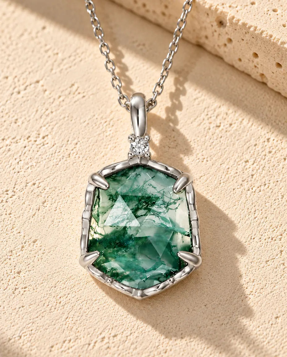 Sechseckige Moosachat Kette aus 925 Sterlingsilber - auf heller Strukturfläche neben einem Travertinblock liegend