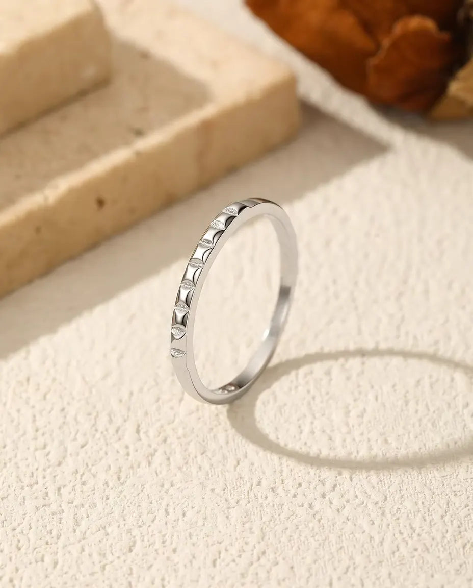 Nieten Stapelring aus 925 Sterlingsilber - aufrecht stehend auf heller Strukturfläche