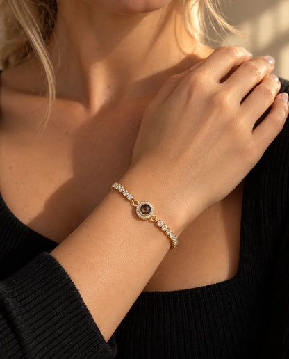 Nahaufnahme des goldfarbenen Tennisarmbands mit Halo-Anhänger am Handgelenk nahe dem Schlüsselbein