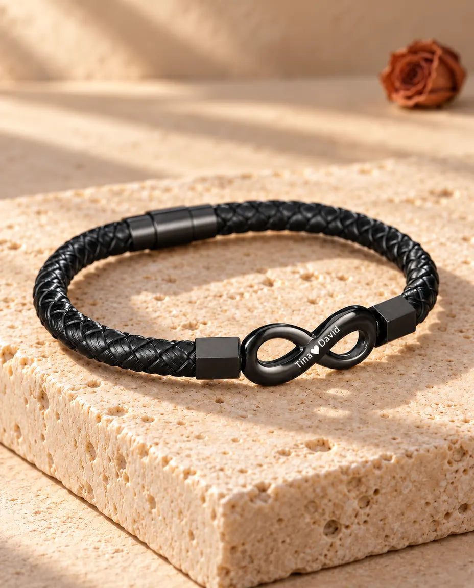Herrenarmband mit graviertem Unendlichkeitszeichen und Magnetverschluss in Dreiviertelansicht auf Travertin