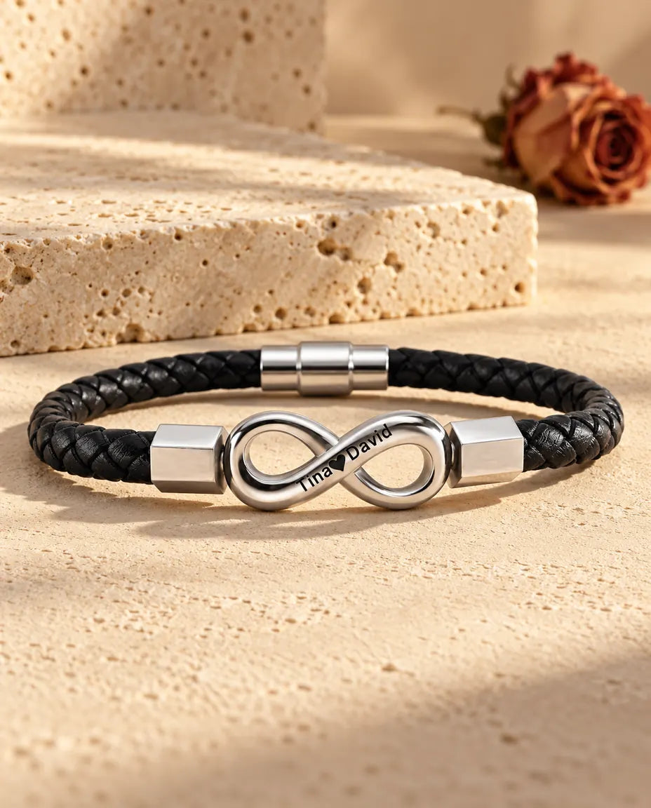 Silberfarbenes Unendlichkeitszeichen aus Edelstahl mit sechskantigen Endkappen an einem schwarzen Kunstlederarmband
