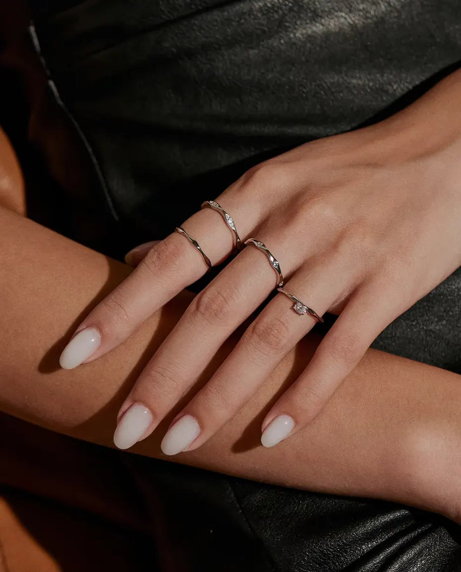 Welliger Moissanit Ring aus 925 Sterlingsilber - zusammen mit weiteren Ringen getragen, Hände übereinander